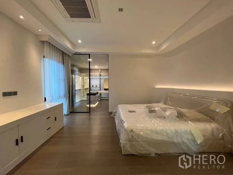 Detached House for sale in Saphan Sung, Bangkok - Spacious master bedroom with built-in cabinetry and a glass door to the walk-in closet.