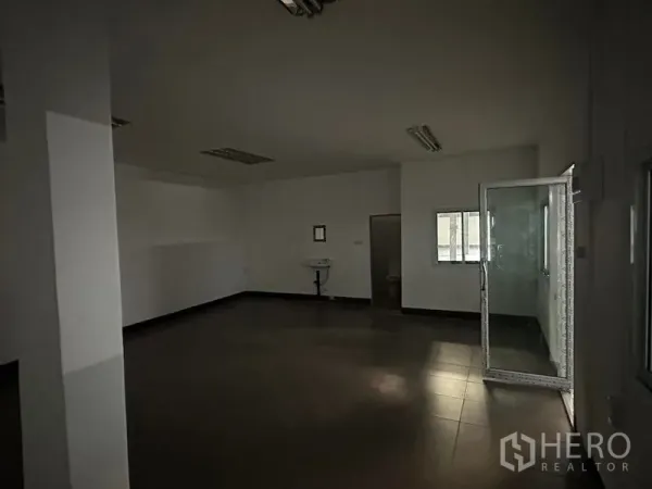 Warehouse for rent in Khan Na Yao, Bangkok - Simple internal office room with glass door, tiled flooring and a wall‑mounted sink.