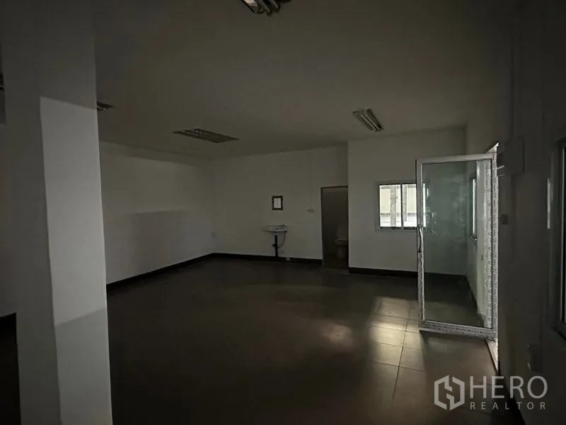 Warehouse for rent in Khan Na Yao, Bangkok - Simple internal office room with glass door, tiled flooring and a wall‑mounted sink.