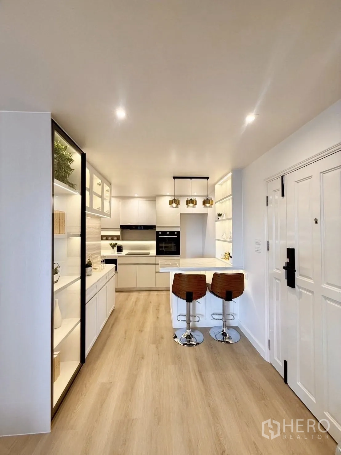 公寓 for rent or sale in Yan Nawa, Bangkok - 开放式白色厨房，带大理石中岛吧台、吊灯与木地板。