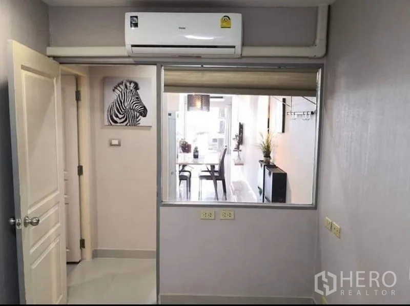 公寓 出租在Khlong Toei, Bangkok - 房间一角，挂壁空调与室内窗可望向餐厅