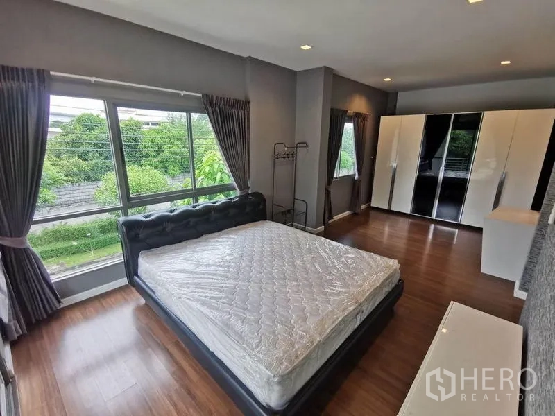 บ้าน ให้เช่าในPrawet, Bangkok - ห้องนอนใหญ่กว้างขวาง มีหน้าต่างบานใหญ่ เตียงคู่ และตู้เสื้อผ้า มองเห็นพื้นที่สีเขียว