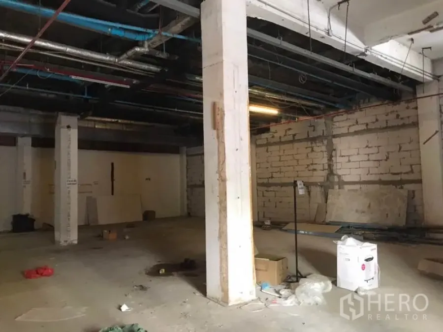 Retail Space for rent in Khlong Toei, Bangkok - Unfitted retail interior with open-plan concrete floor, exposed ceiling pipes and structural columns in Bangkok.