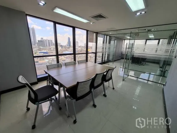 Office Space for rent - Boardroom with long table, glass partitions and wide city views in a Bang Rak office space.