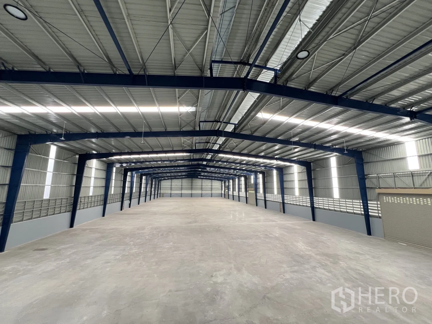 Warehouse for rent in Mueang Samut Prakan, Samut Prakan - Long central aisle of the warehouse highlighting clear-span structure and roof lights.
