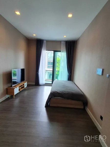 Detached House for rent in Khlong Luang, Pathum Thani - Long bedroom with single bed, balcony access and recessed ceiling lights.