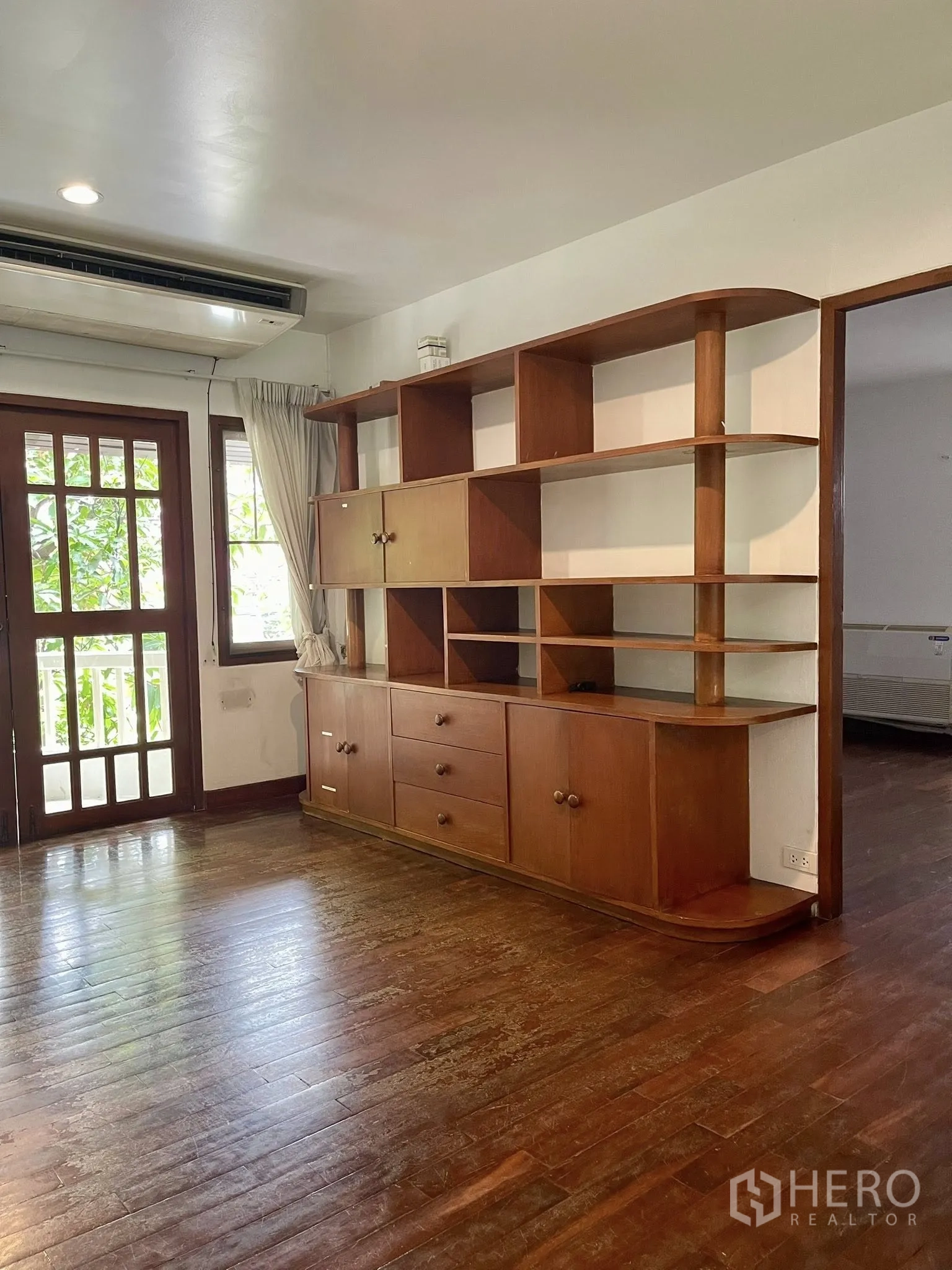 Detached House for rent in Pathum Wan, Bangkok - Room with custom wooden shelving and a door to a small balcony.