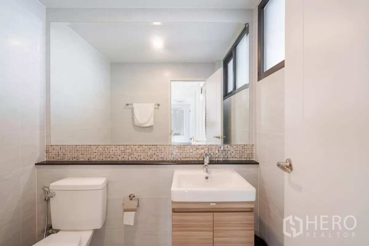 Detached House for sale in Saphan Sung, Bangkok - Bathroom with mosaic trim, vanity and toilet.