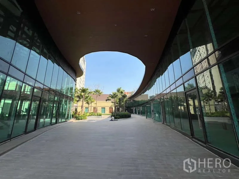 Retail Space for rent in Watthana, Bangkok - Open pedestrian walkway between twin glass retail blocks under a wooden canopy.