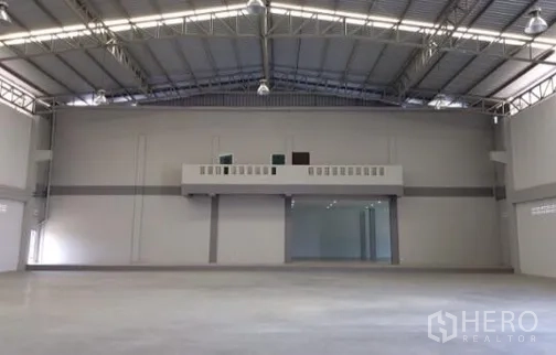 Factory for rent or sale in Bang Sao Thong, Samut Prakan - High-ceiling warehouse hall with mezzanine and polished concrete floor.
