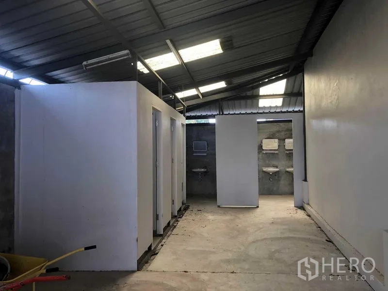 货栈 出租在Prawet, Bangkok - 员工卫生间区域，多个独立隔间与洗手池，金属屋顶