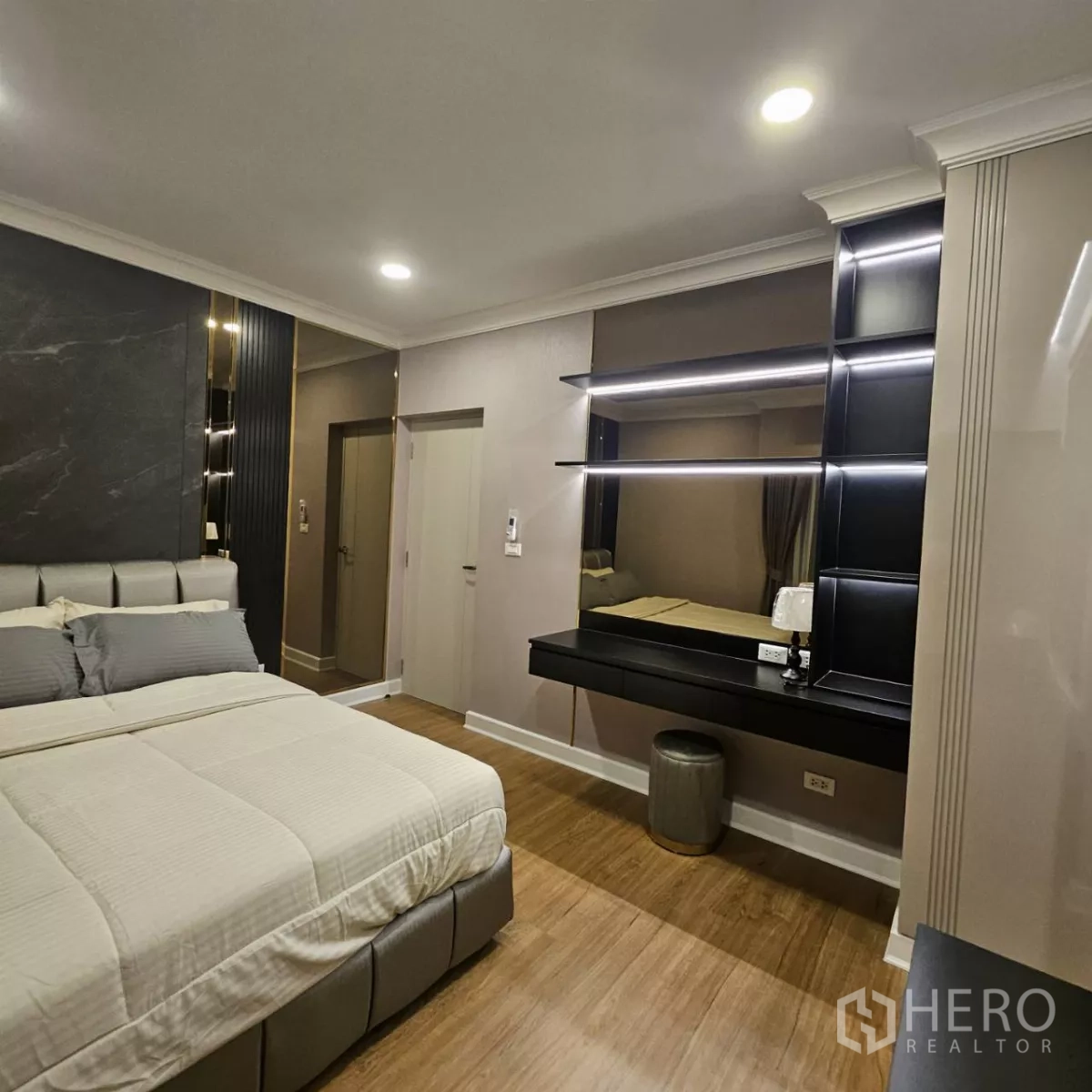 独立式住宅 出租在Bang Phli, Samut Prakan - 卧室另一角度，特大床、发光层架、梳妆台与暖色木地板。