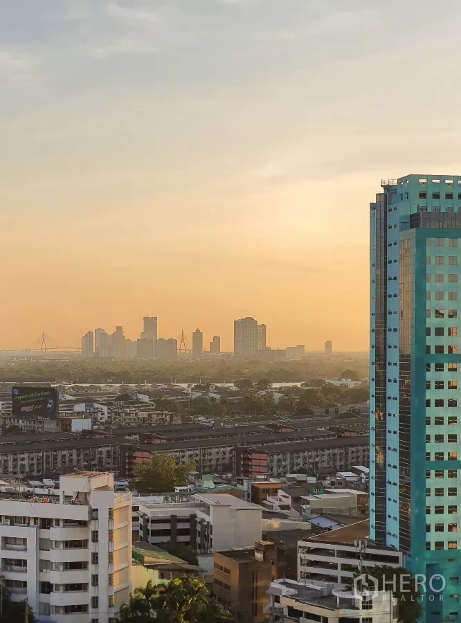 Condominium for rent in Khlong Toei, Bangkok - High‑floor Bangkok skyline and sunset view from the condo balcony.