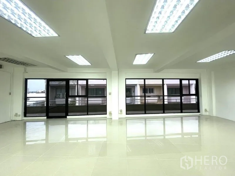 办公空间 出租在Khlong Toei, Bangkok - 一排落地推拉窗为办公室引入自然光。