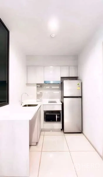 公寓 出租或出售在Pathum Wan, Bangkok - 紧凑白色厨房，内置柜体、灶台与不锈钢冰箱