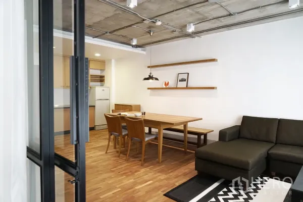 公寓 出租在Watthana, Bangkok - 餐厅连接紧凑厨房，配冰箱，外露混凝土顶与木地板。