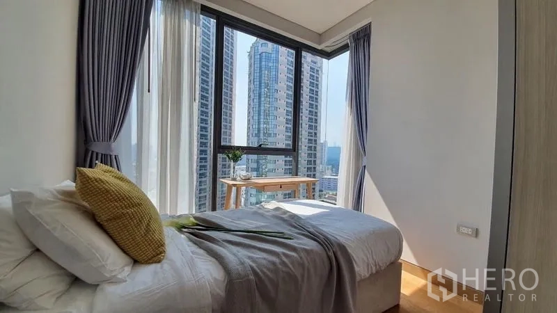 公寓 出租在Khlong Toei, Bangkok - 次卧单人床与转角大窗，眺望摩天楼。