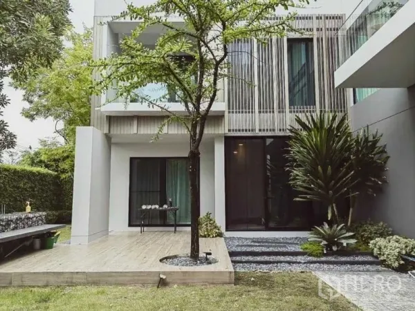 独立式住宅 出租 - 现代三层独栋别墅外观，带景观庭院、木平台与落地玻璃门。