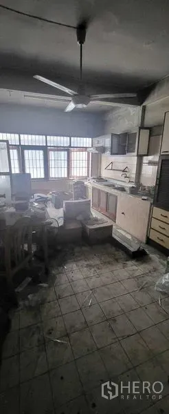 Shophouse for rent in Khlong Toei, Bangkok - Older tiled kitchen with cabinets, window wall and ceiling fan ready for refurbishment.