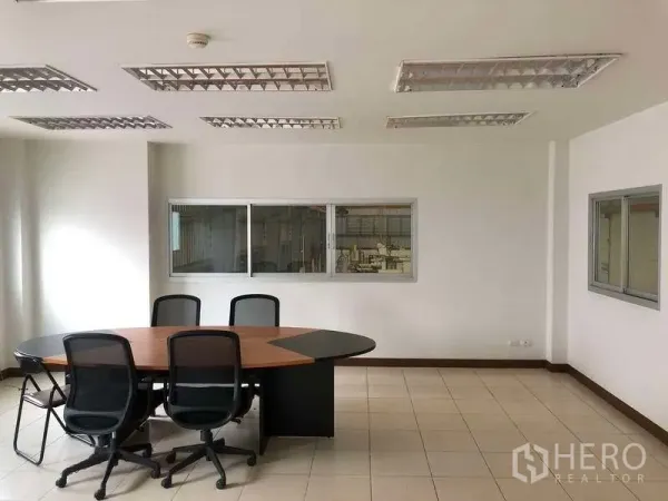 Factory for rent in Bang Sao Thong, Samut Prakan - Bright meeting room with oval conference table and windows overlooking the factory floor.