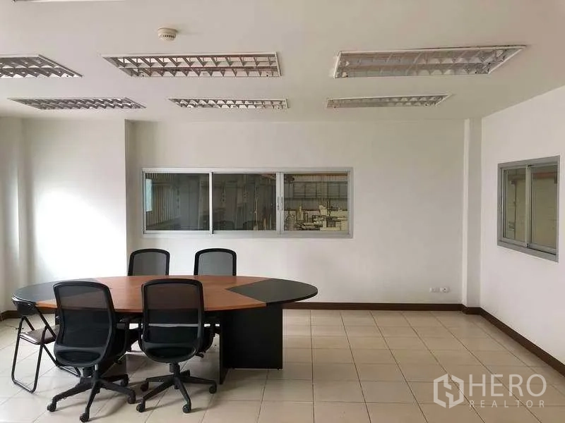 Factory for rent in Bang Sao Thong, Samut Prakan - Bright meeting room with oval conference table and windows overlooking the factory floor.