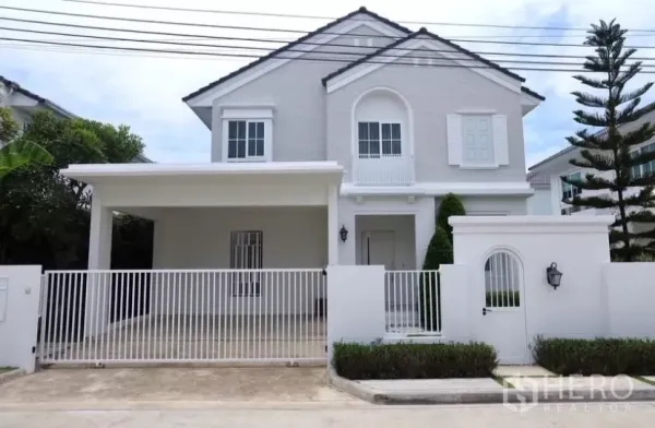 独立式住宅 出租在Bang Phli, Samut Prakan - 白色两层独栋别墅，带前院铁门与有顶车位，社区宁静。