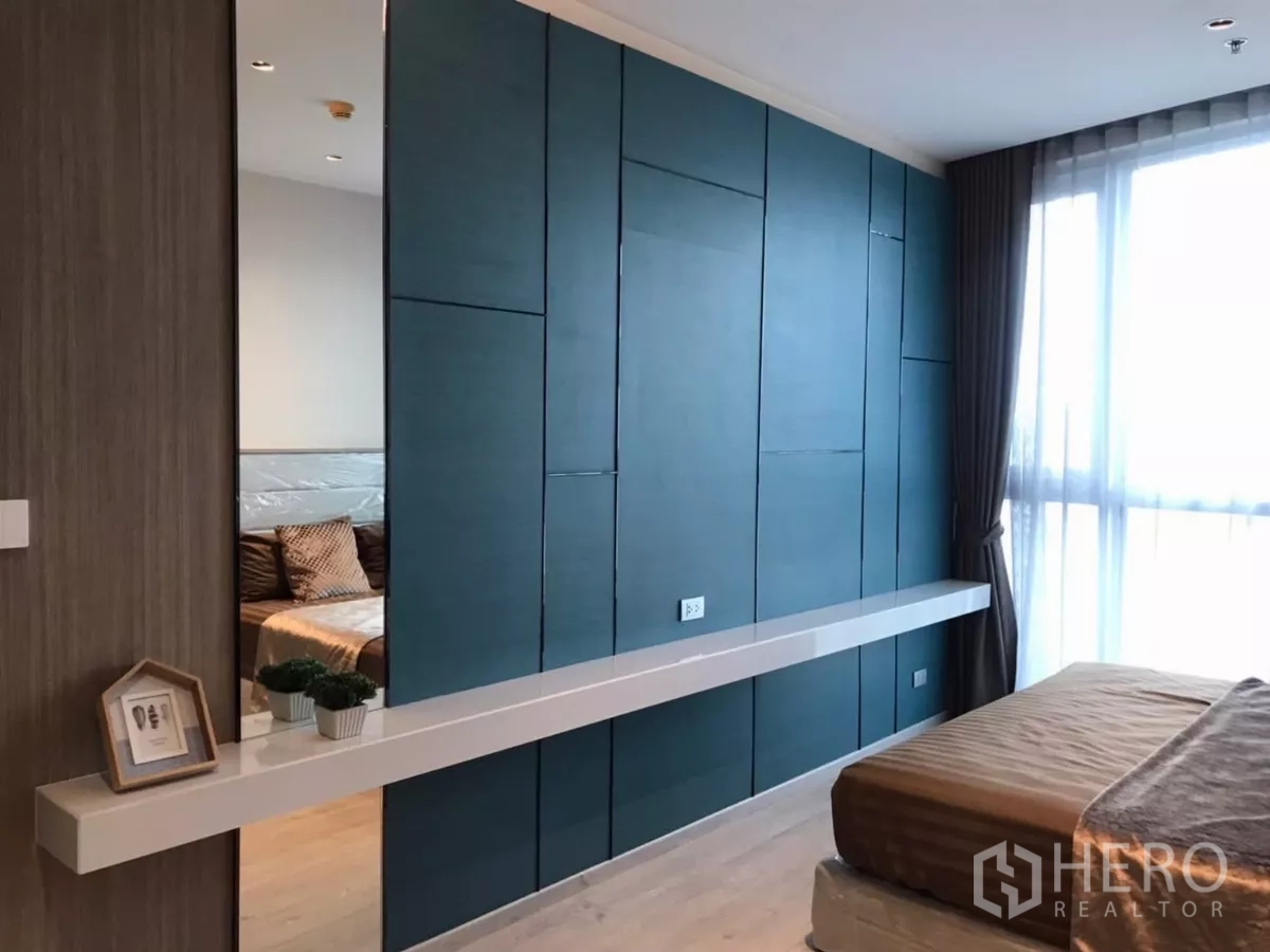公寓 出租在Watthana, Bangkok - 卧室展示蓝绿色装饰墙面、悬浮搁板与大窗户采光。