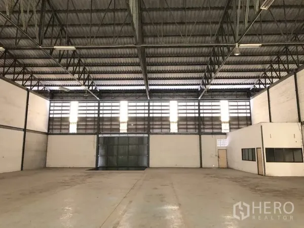 货栈 出租在Khlong Luang, Pathum Thani - 宽敞仓库内部，高位钢桁架屋顶，百叶高窗与大型金属推拉门