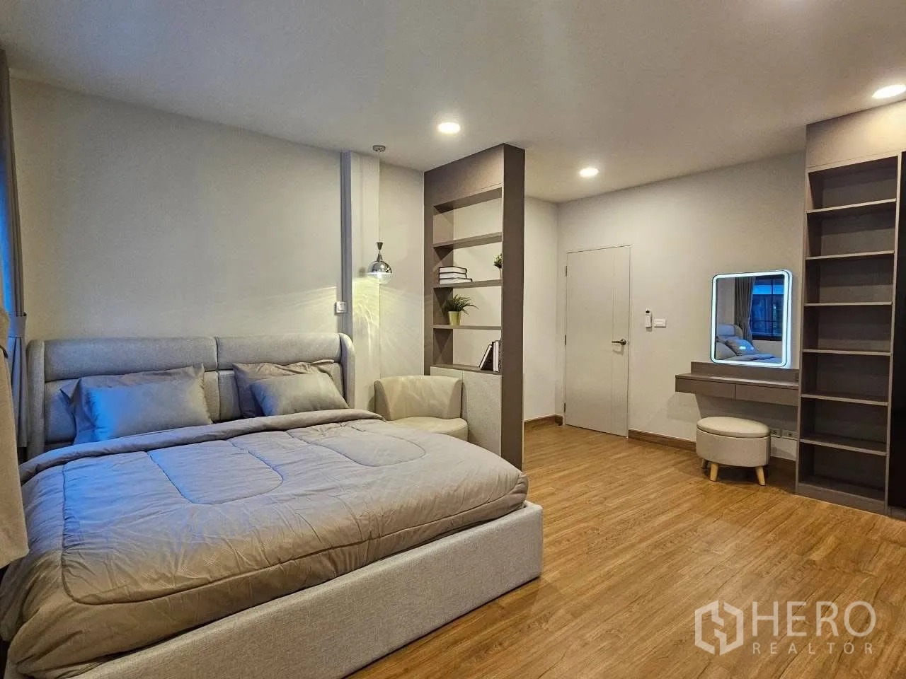 Detached House for rent or sale in Bang Phli, Samut Prakan - Spacious bedroom with king bed, open shelving divider, and vanity.