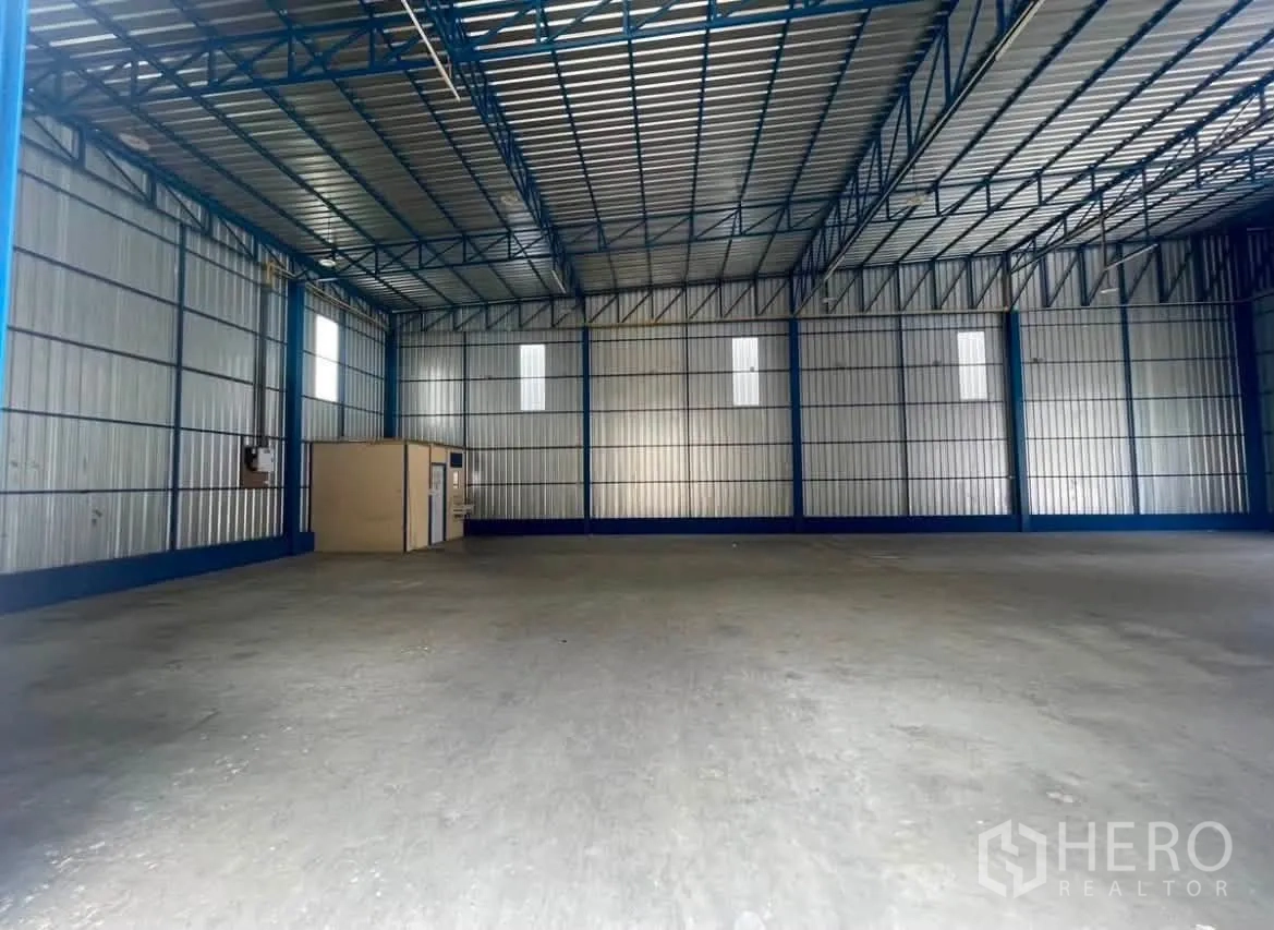 仓库 for rent in Wang Thonglang, Bangkok - 仓库内部展示入口区域与宽阔地面，金属屋顶覆盖。