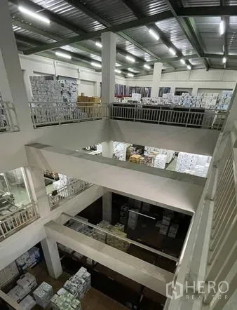 Warehouse for sale in Bangkok Yai, Bangkok - Multi‑level mezzanine storage area with high ceiling and guardrails.
