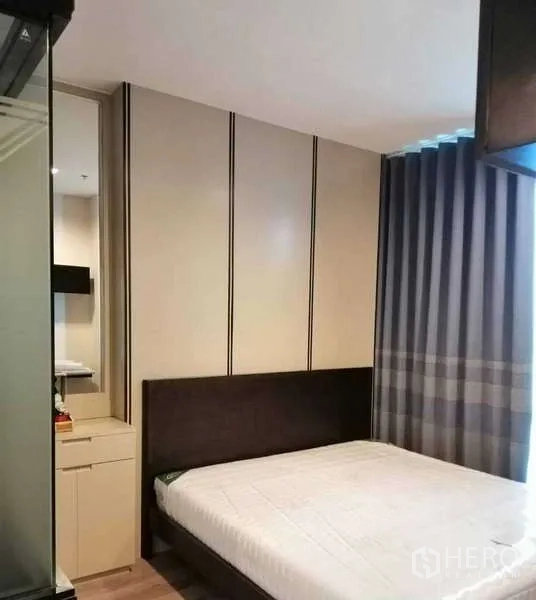 คอนโด ให้เช่าหรือขาย - ห้องนอนหลักพร้อมตู้เสื้อผ้าบิลท์อิน หัวเตียงบุผ้า และผ้าม่านทึบ