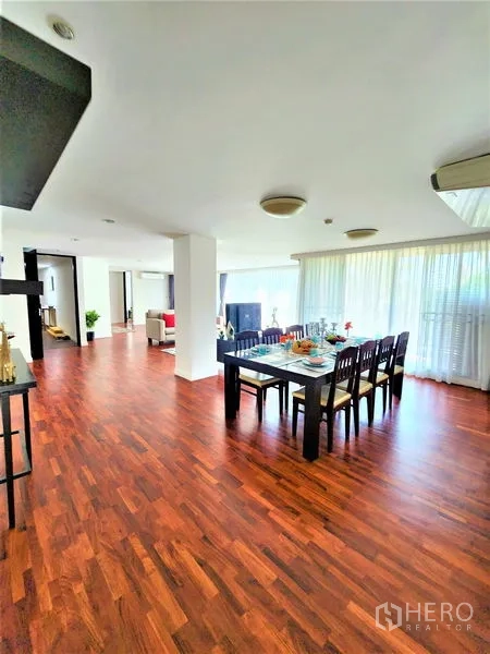 Condominium for rent in Bang Rak, Bangkok - Bright dining space with a six-seat table beside large windows and hardwood floors.