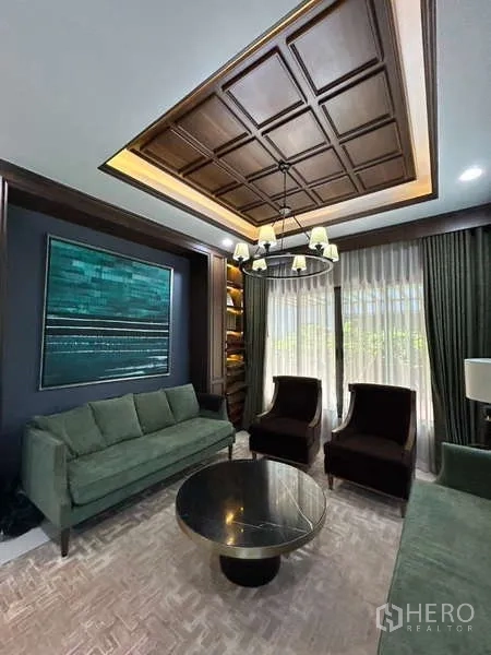 Detached House for rent in Bang Kapi, Bangkok - Living area close-up showing coffered wood ceiling, sofa set, and coffee table.