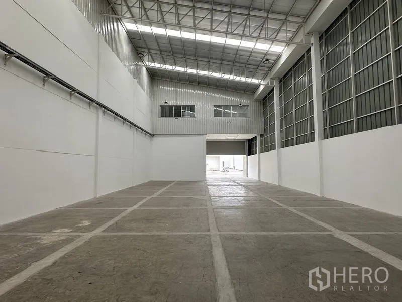 工厂 出租在Khlong Luang, Pathum Thani - 仓库内部朝向入口，可见夹层窗户与屋架结构。