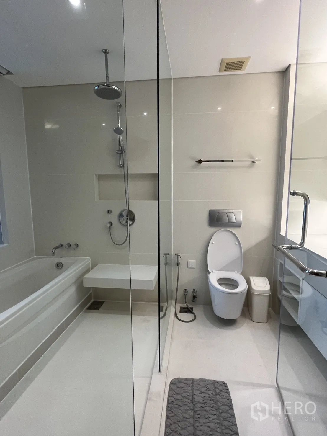 Condominium for rent in Watthana, Bangkok - Spacious bathroom with bathtub, glass shower, and modern toilet.