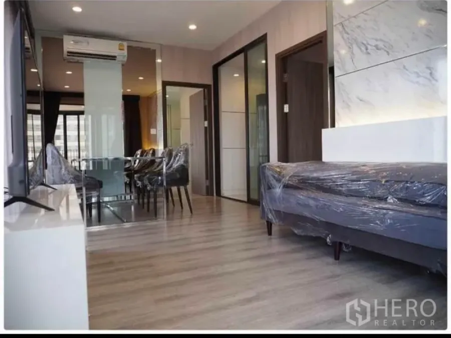 คอนโด ให้เช่าในHuai Khwang, Bangkok - ห้องนั่งเล่นและรับประทานอาหารสว่าง พื้นไม้ ผนังลายหินอ่อน กั้นกระจก และเครื่องปรับอากาศ