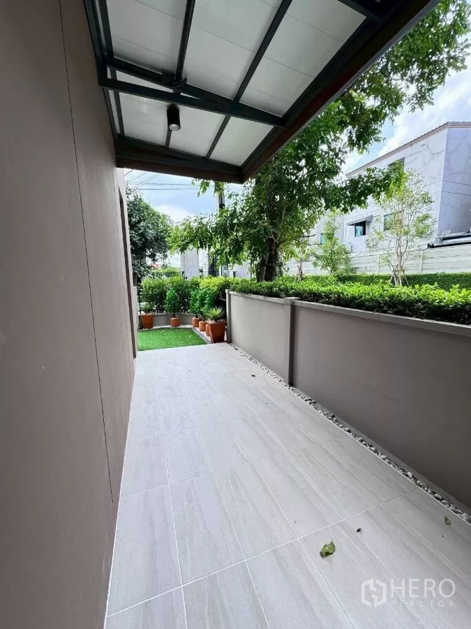 Townhouse for rent in Saphan Sung, Bangkok - Covered side terrace overlooking hedges and mature trees.