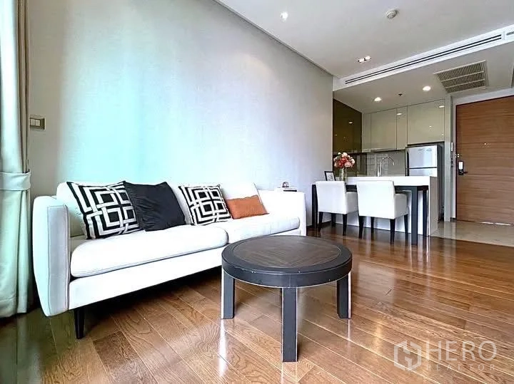 公寓 for rent in Khlong Toei, Bangkok - 客厅设白色沙发、圆形茶几、用餐区与紧凑厨房。