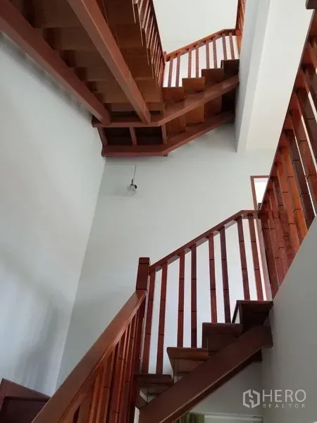 Townhouse for rent in Bang Kapi, Bangkok - Detail of wooden staircase rising through a light-filled stairwell.