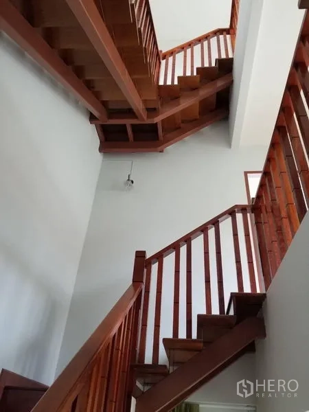 Townhouse for rent in Bang Kapi, Bangkok - Detail of wooden staircase rising through a light-filled stairwell.