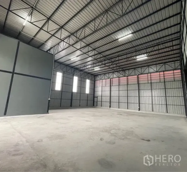 Warehouse for rent or sale in Lam Luk Ka, Pathum Thani - Spacious high-ceiling warehouse hall with steel trusses and skylight panels.