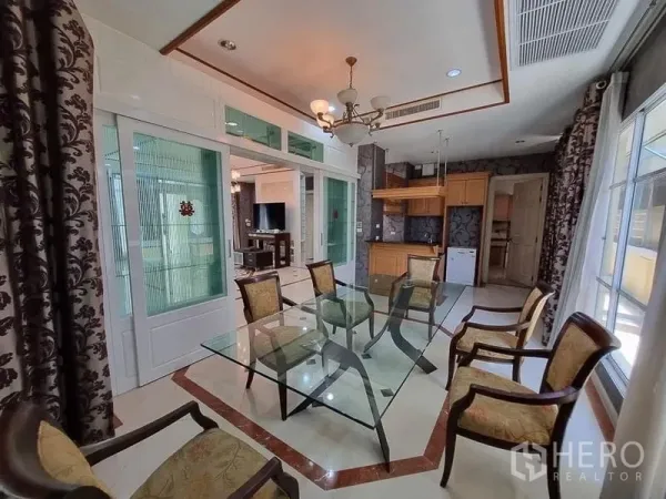 Detached House for rent in Yan Nawa, Bangkok - Dining area with glass table and six chairs opening to pantry and glass sliding partitions.