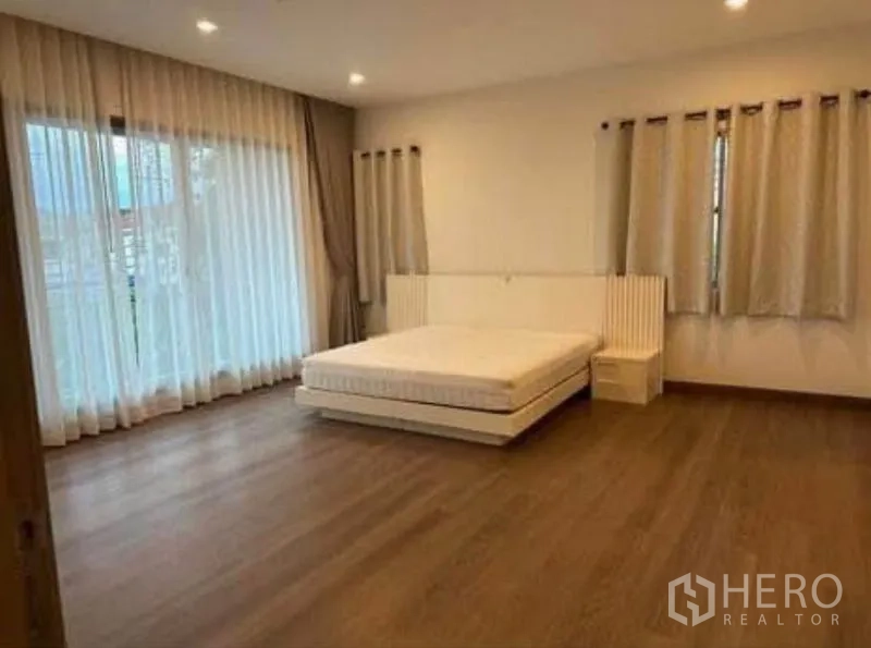 Detached House for rent - Primary bedroom with bed platform, wood floors, and balcony access.