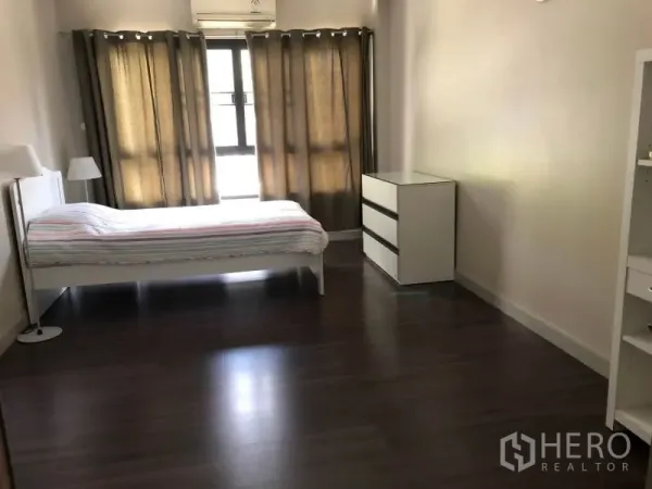 房间 出租在Khlong Toei, Bangkok - 卧室配深色木地板与大窗，白色床架和抽屉柜。