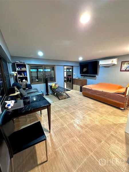 Detached House for sale in Bang Bua Thong, Nonthaburi - Open-plan living area with sofa set, wall-mounted TV, dining table and tiled floors.
