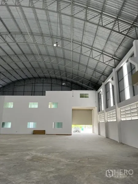 工厂 出租或出售在Bang Bo, Samut Prakan - 宽敞生产大厅，高挑拱形钢屋顶，白色办公室区与大型卷帘门。