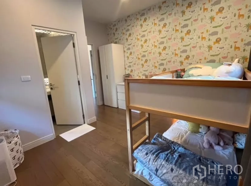 独立式住宅 出租在Prawet, Bangkok - 儿童房带高低床、趣味壁纸与卫浴入口。