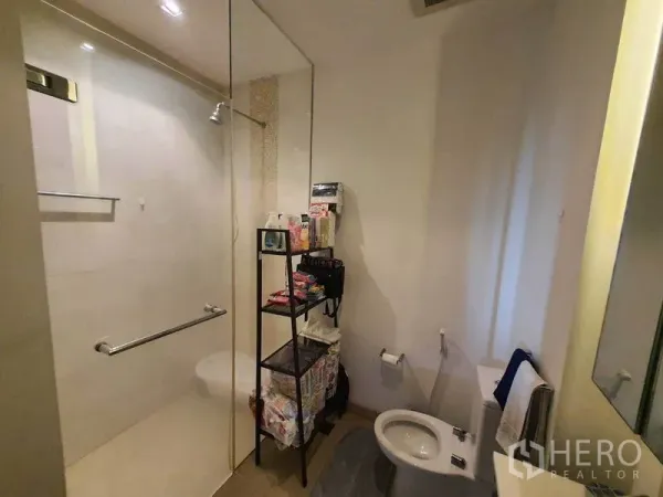 公寓 出租在Yan Nawa, Bangkok - 现代浴室，玻璃淋浴间、坐便与收纳架。