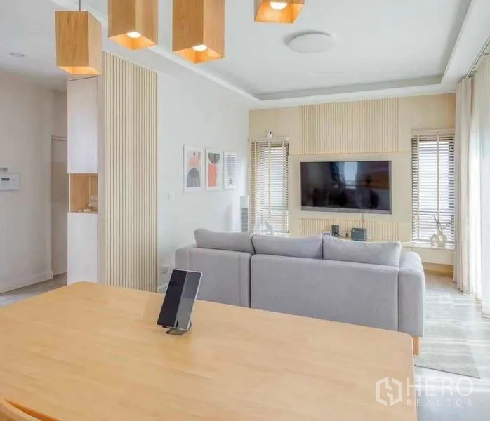 บ้าน ให้เช่าในBang Khun Thian, Bangkok - ห้องนั่งเล่นมองไปยังผนังทีวี ฟีเจอร์วอลล์ไม้ และโซฟาขนาดใหญ่